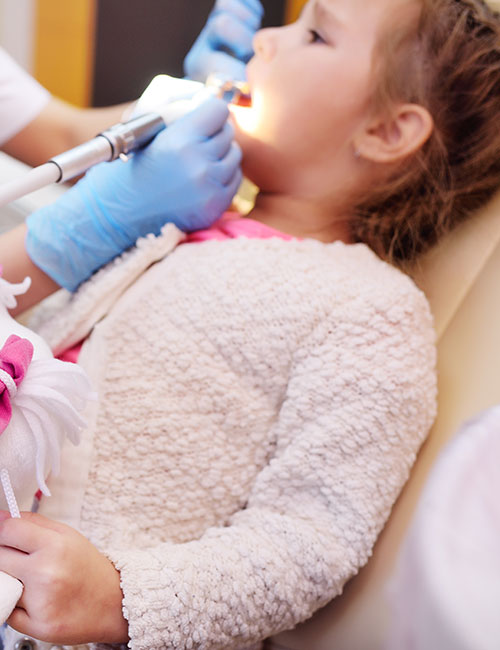 dentist-examines-child-s-teeth-dental-chair